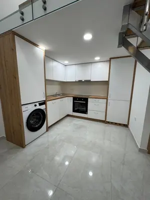 a kitchen with white cabinets and a washer at Basilica in Maribor