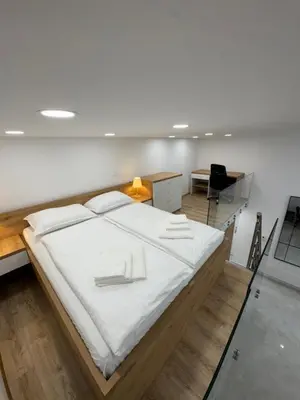 a bedroom with a large bed with white sheets at Basilica in Maribor