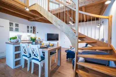 a kitchen and dining room with a staircase and a table and chairs at Cozy House Claudia in Žirovnica
