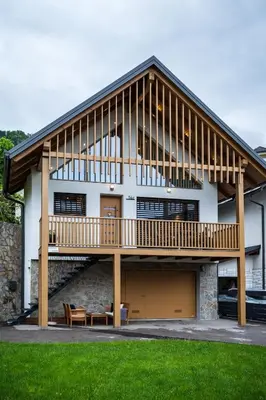 a large house with a large deck on top of it at Cozy House Claudia in Žirovnica