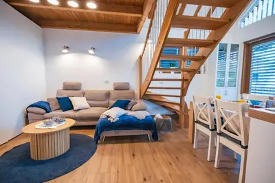 a living room with a couch and a staircase at Cozy House Claudia in Žirovnica