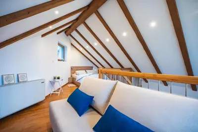 a living room with a white couch and blue pillows at Cozy House Claudia in Žirovnica