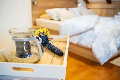 a box with a vase of flowers on a table in a bedroom at Cozy House Claudia in Žirovnica