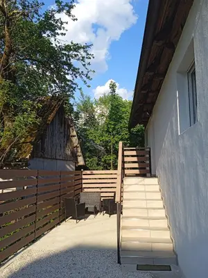 a set of stairs next to a house with a fence at Apartment One2one in Bovec