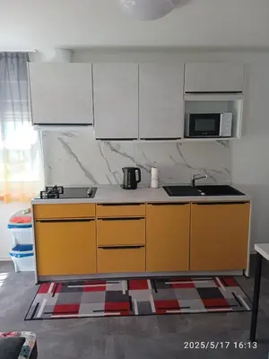 a kitchen with yellow cabinets and a sink at Apartment One2one in Bovec