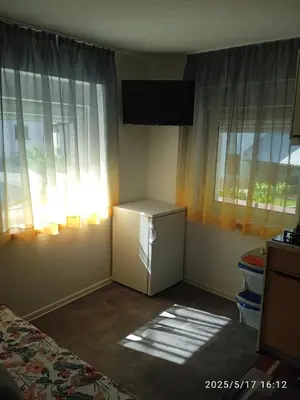 a room with a small refrigerator and two windows at Apartment One2one in Bovec