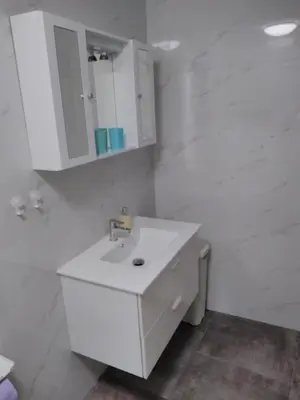 a white bathroom with a sink and a mirror at Apartment One2one in Bovec