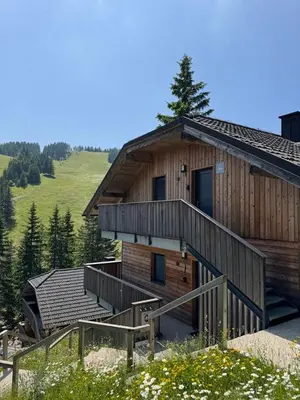 a log cabin with a staircase next to a building at OTTA Apartments Golte C1 in Mozirje