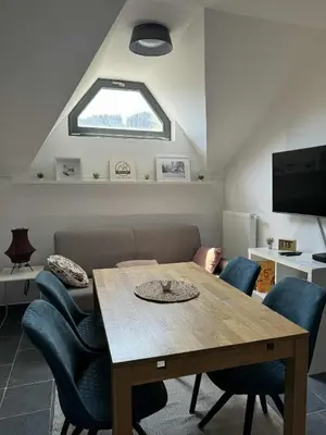 a table and chairs in a living room with a window at OTTA Apartments Golte C1 in Mozirje