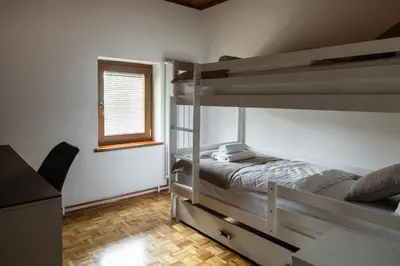 a bedroom with two bunk beds and a window at Wellba Holiday Home Otlica in Ajdovščina
