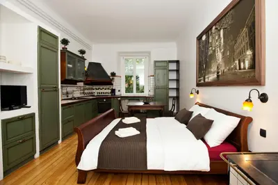 a bedroom with a bed and a kitchen at Zois Apartments in Ljubljana
