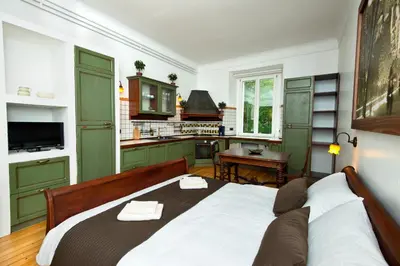 a bedroom with a large bed and a kitchen at Zois Apartments in Ljubljana