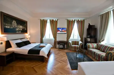 a bedroom with a bed and a living room with a couch at Zois Apartments in Ljubljana