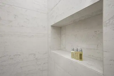 three bottles of oils sitting on a shelf in a bathroom at Zois Apartments in Ljubljana