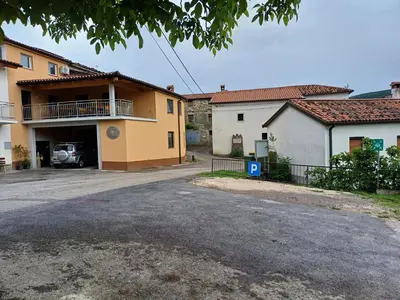 a parking lot in front of a house at Apartments Pr' Užlejbvih in Podnanos