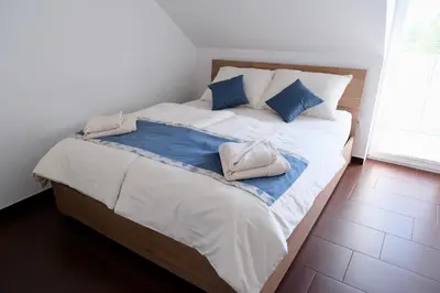 a bed with two pillows on it in a room at Apartma z dvema spalnicama in balkonom in Maribor