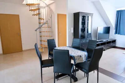 a dining room with a table and chairs at Apartma z dvema spalnicama in balkonom in Maribor
