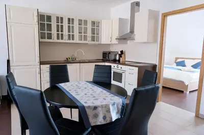 a kitchen with a table and chairs and a bed at Apartma z dvema spalnicama in balkonom in Maribor