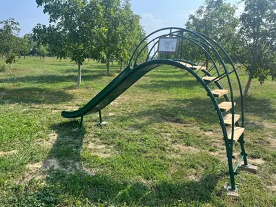 a slide in a park in a field at Apartments Wally in Ptuj