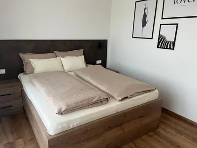 a bedroom with a large bed with a wooden frame at Apartments Wally in Ptuj