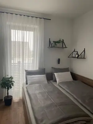 a bedroom with two beds and a window at Apartments Wally in Ptuj