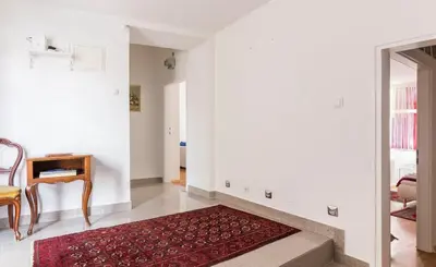 a living room with white walls and a red rug at E&E Apartments in Ljubljana