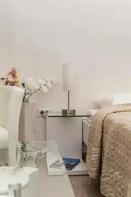 a bedroom with a bed and a table with a lamp at E&E Apartments in Ljubljana