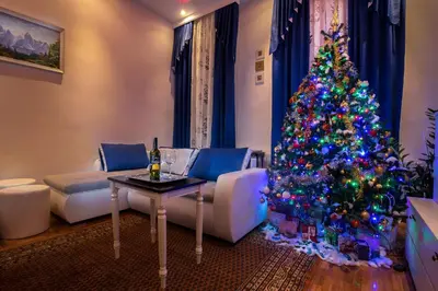 a christmas tree in a living room with a table at E&E Apartments in Ljubljana