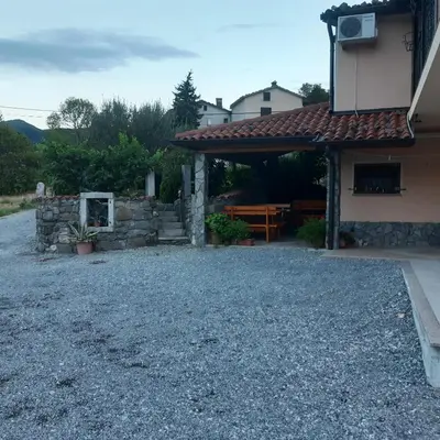 a house with a gravel yard next to a building at APARTMA in SOBE PILIH in Vipava