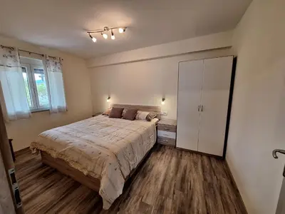 a bedroom with a large bed and a white cabinet at APARTMA in SOBE PILIH in Vipava