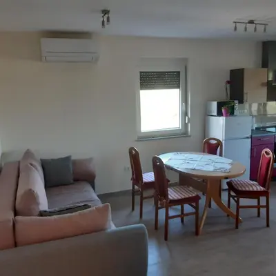 a living room with a couch and a table with chairs at APARTMA in SOBE PILIH in Vipava