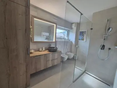 a bathroom with a sink and a glass shower at TaWorld apartment in Šmartno pri Litiji