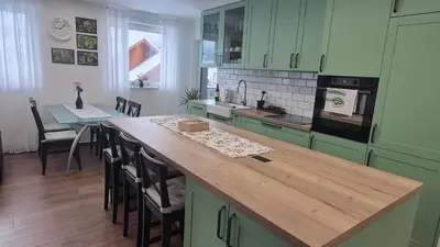 a kitchen with green cabinets and a wooden counter top at TaWorld apartment in Šmartno pri Litiji