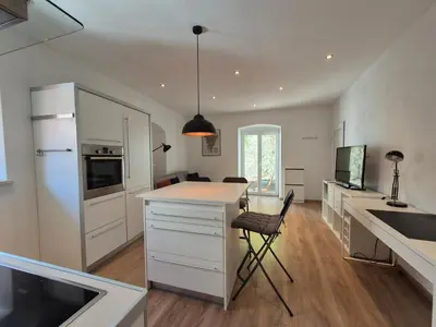 a kitchen with white cabinets and a white counter top at Valle Apartment City Center in Ljubljana