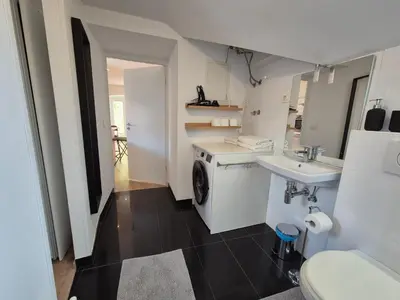 a bathroom with a washing machine and a sink at Valle Apartment City Center in Ljubljana