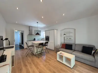 a living room and kitchen with a couch and a table at Valle Apartment City Center in Ljubljana