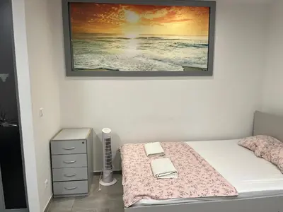 a bedroom with a bed with a picture on the wall at New Modern App in Ljubljana