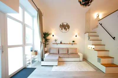 a living room with a couch and stairs at Urska's adorable place in Ljubljana