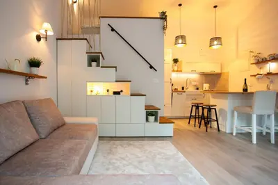 a living room with a couch and a kitchen at Urska's adorable place in Ljubljana