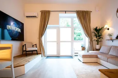 a living room with a couch and a large window at Urska's adorable place in Ljubljana