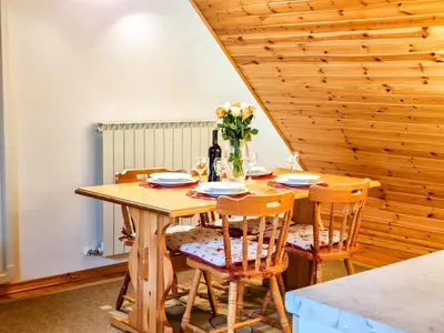 a wooden table with chairs and a bottle of wine at Apartmaji Čok in Bovec