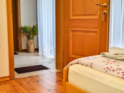 a bedroom with a bed and a door with a plant at Apartmaji Čok in Bovec