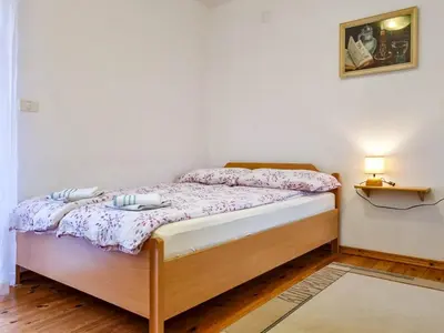 a small bedroom with a bed with a table at Apartmaji Čok in Bovec