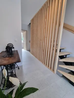 a hallway with a wooden staircase and a table at Rozalija house - Počitniška hiša z vrtom ob reki Soči v Solkanu in Solkan