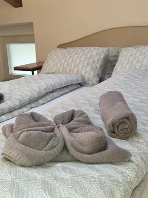 a bed with two towels on top of it at Rozalija house - Počitniška hiša z vrtom ob reki Soči v Solkanu in Solkan
