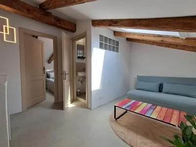 a living room with a blue couch and a table at Rozalija house - Počitniška hiša z vrtom ob reki Soči v Solkanu in Solkan