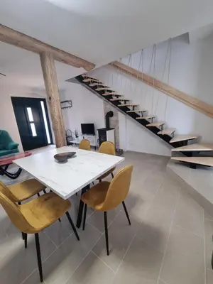 a dining room with a white table and chairs at Rozalija house - Počitniška hiša z vrtom ob reki Soči v Solkanu in Solkan