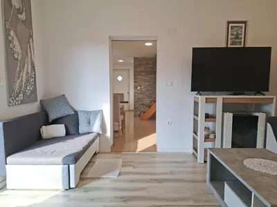 a living room with a couch and a flat screen tv at Holiday house Zala in Puconci