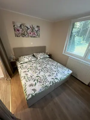 a bedroom with a bed with a floral bedspread at Dih narave in Stahovica