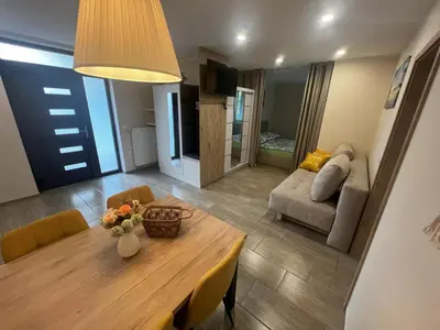 a living room with a dining room table and a couch at Dih narave in Stahovica